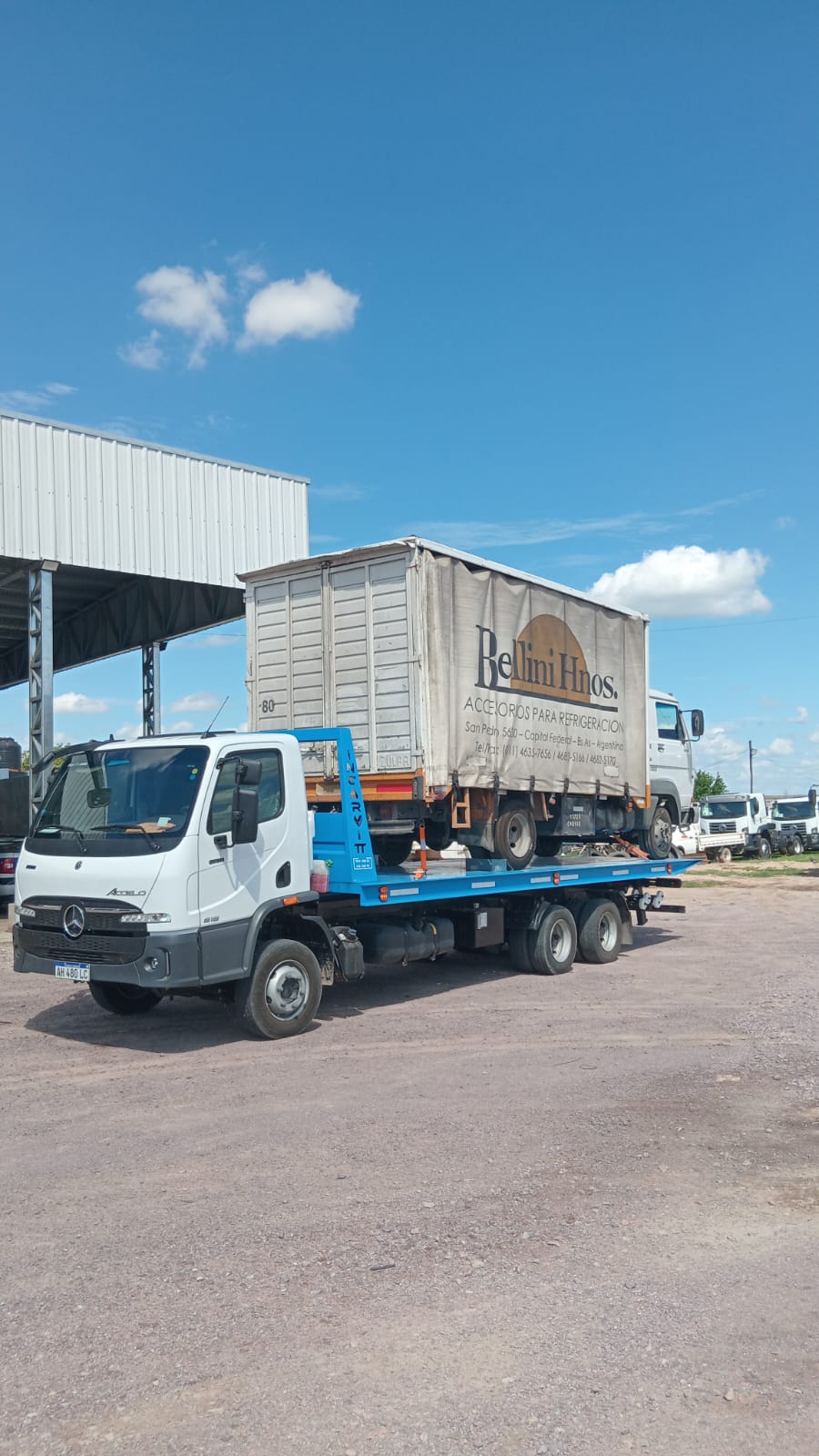 Servicio de grúa trasladando camión de reparto